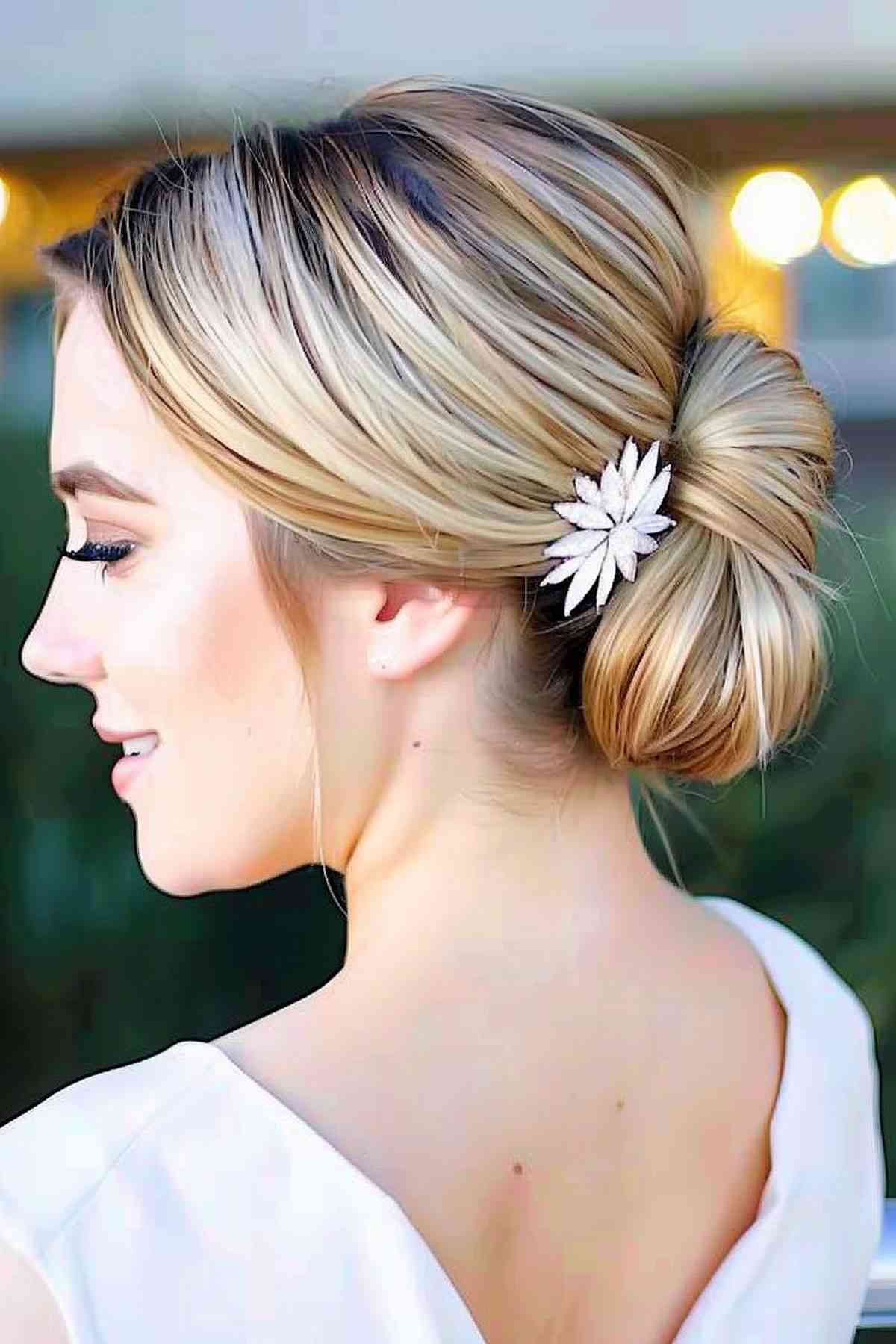 Polished low bun with a floral accessory for gala elegance.