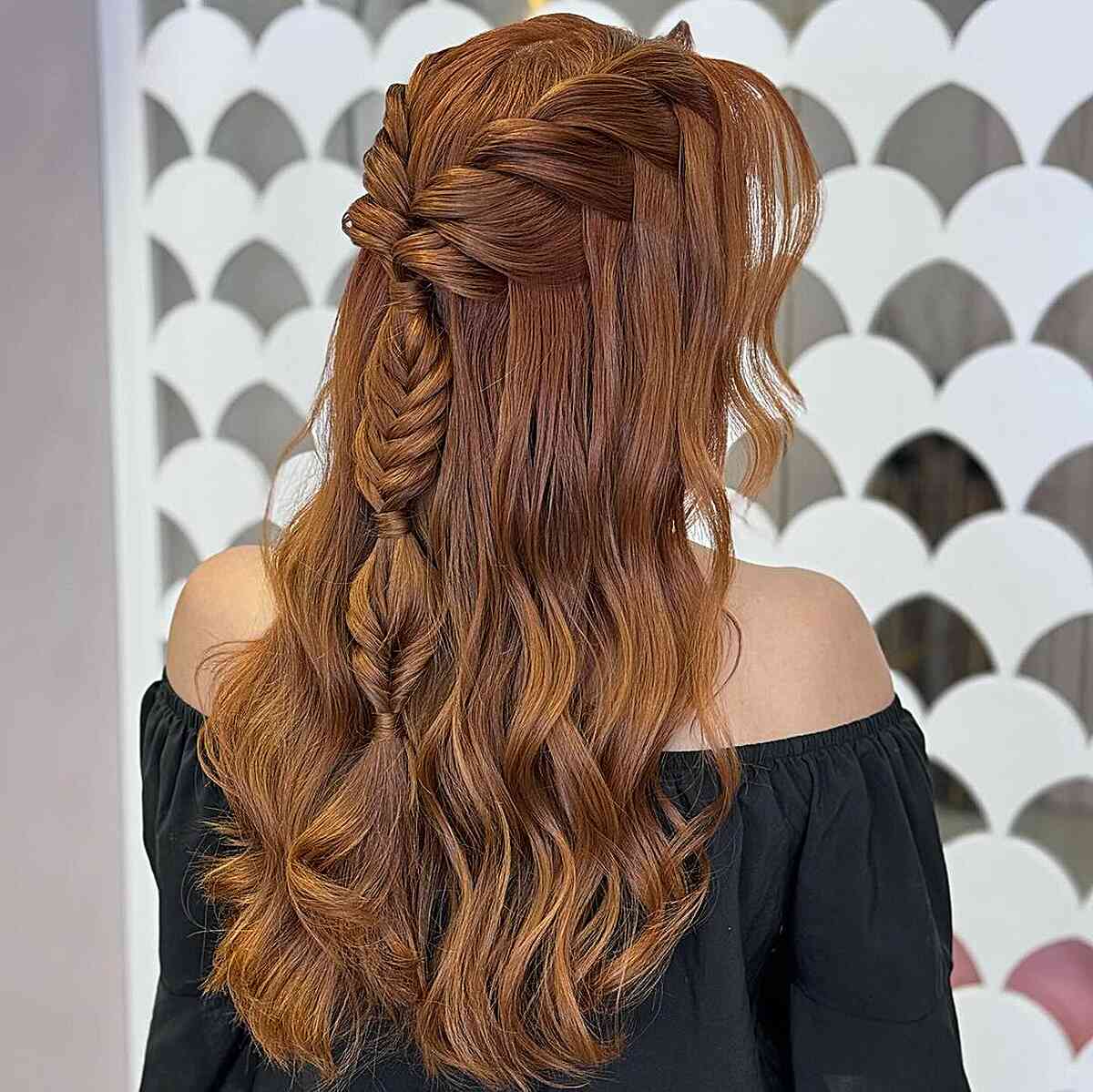 Gala-inspired braided half updo with soft waves for longer hair