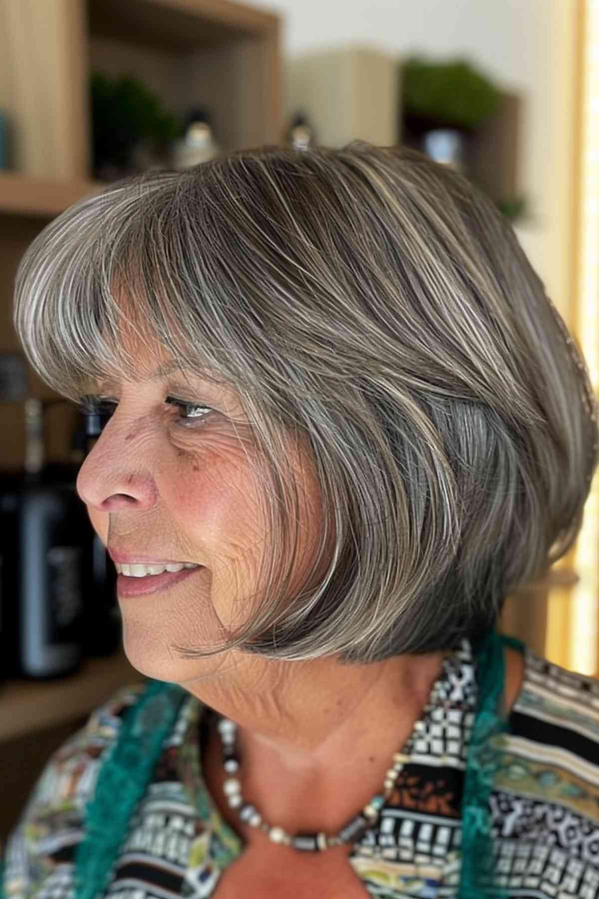 A sophisticated middle-aged woman with glamorous gray hair and chic bangs that complement her natural elegance.